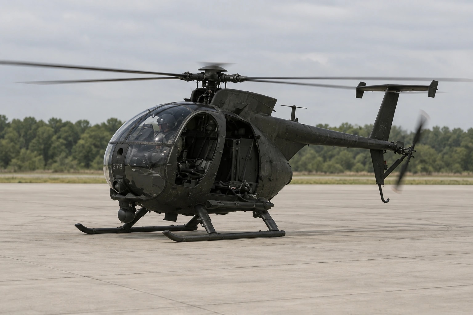 A Little Bird transport helicopter on a landing pad.